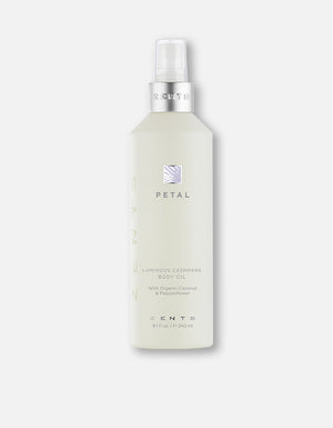 A frosted bottle of Body Oil | Zents with a silver pump and minimalist labeling, featuring organic coconut and passionflower ingredients for skincare and body care.
