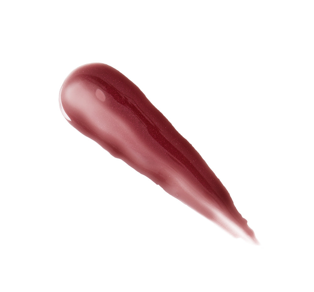 Plump Up Pretty Peptide Lip Treatment | Farmhouse Fresh tube with a metal applicator, placed next to a smear of rosy lip treatment and a bitten peach slice on a light background.