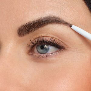 Close-up of a person applying eyebrow makeup with the PureBrow Precision Pencil | Jane Iredale, enhancing the natural brow shape with precise strokes.