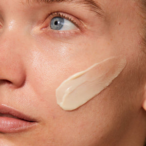Close-up of a woman’s face with a smooth, creamy application of Rejuvenating Night Cream | Omorovicza on her cheek, highlighting skincare and hydration benefits.