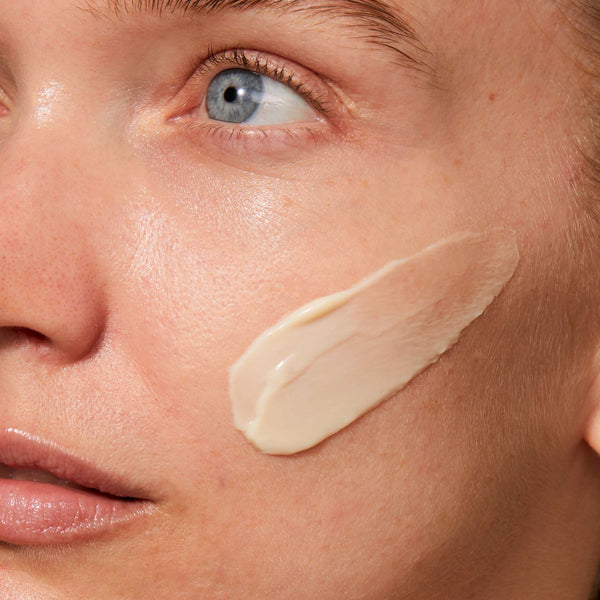 Close-up of a woman’s face with a smooth, creamy application of Rejuvenating Night Cream | Omorovicza on her cheek, highlighting skincare and hydration benefits.