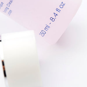 Close-up of a pink bottle labeled Rosée Visage (Toning Cleansing Lotion) | Phytomer with volume 250 ml - 8.4 fl oz, accompanied by a white cosmetic container, showcasing skincare products for gentle cleansing and toning.