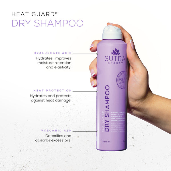 Hand holding a lavender can of Heat Guard Dry Shampoo | SUTRA with text highlighting benefits including hyaluronic acid for hydration, heat protection, and volcanic ash for detoxifying and oil absorption.