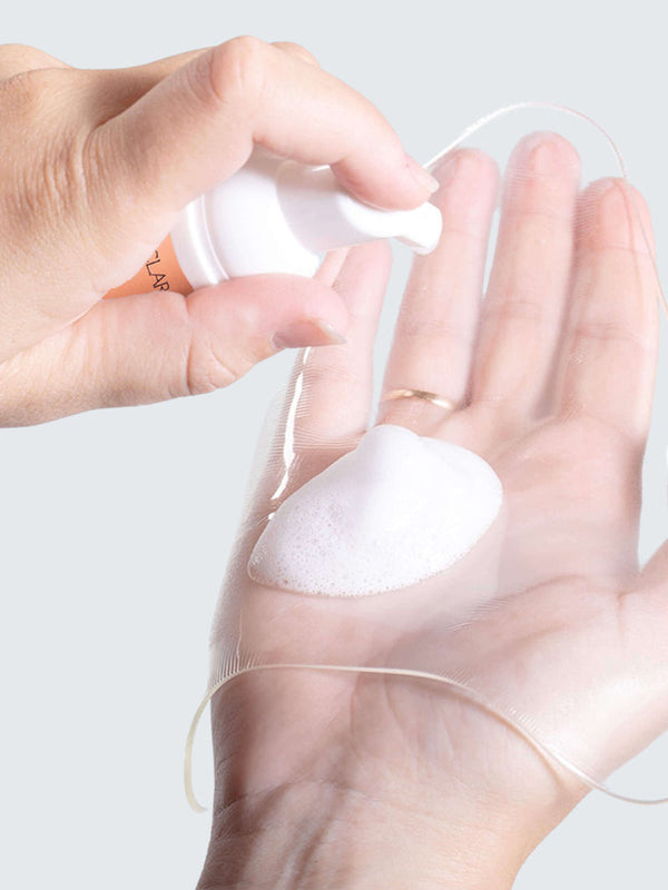 Hand dispensing foamy cleanser onto a clear silicone patch held in the palm, demonstrating the use of Patch Prep Cleanser™ | Dermaclara for skincare and patch cleaning.