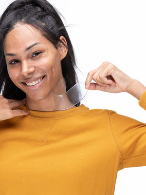 Smiling woman holding a clear silicone neck patch near her skin, demonstrating the use of the SiliconeFusion™ Neck Patch | Dermaclara for skincare and wrinkle reduction.