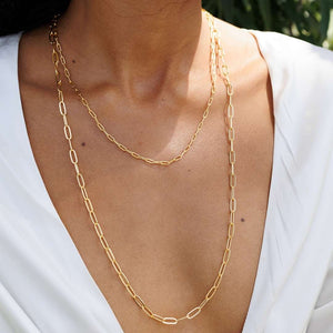 Model wearing layered chain necklaces featuring elongated links with a silver tone finish, representing the Swing Paperclip Necklace - silver tone | Purpose Jewelry.