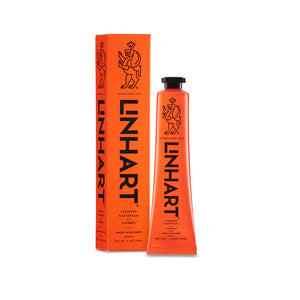 Bright orange tube and box packaging of Linämel Toothpaste | LINHART featuring minimalist black text and a stylized lion logo, designed for dental care and wellness.