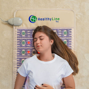 Young woman relaxing on the TAJ-Mat™ Full 7224 Firm - Photon PEMF InfraMat Pro® | HealthyLine with built-in therapy stones and red light for wellness and recovery benefits.