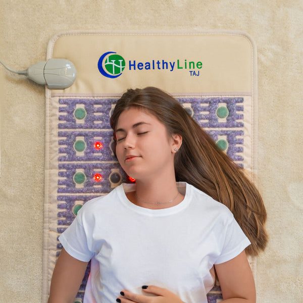 Young woman relaxing on the TAJ-Mat™ Full 7224 Firm - Photon PEMF InfraMat Pro® | HealthyLine with built-in therapy stones and red light for wellness and recovery benefits.