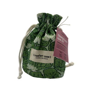 Green patterned drawstring pouch with a label reading [comfort zone] holding the Tranquillity Hair Kit | [ comfort zone ] accompanied by a pink informational tag.