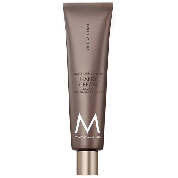 Tube of Hand Cream | Moroccanoil in brown packaging with gold cap, labeled with argan oil and hyaluronic acid for rich nourishment and skincare benefits.