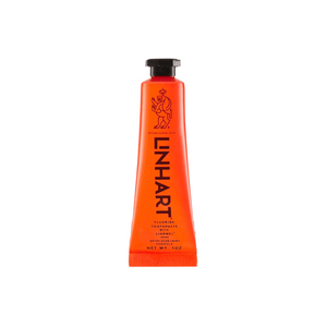 Bright orange tube of Linämel Toothpaste | LINHART featuring bold black text and a minimalist lion illustration, designed for effective oral care.