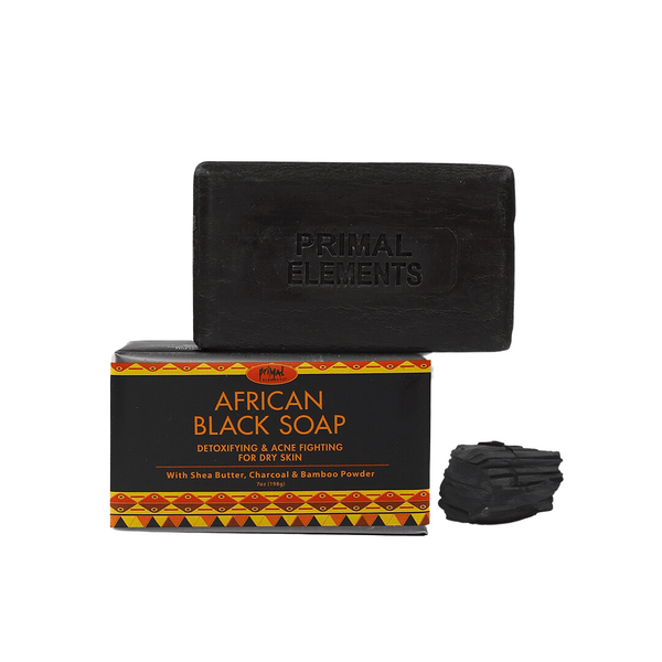 Luxury African Black Soap | Primal Elements bar with packaging and charcoal pieces, highlighting skincare benefits for detoxifying and fighting dry skin.