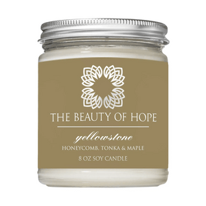 Yellowstone 8oz Candle | The Beauty of Hope in a glass jar with a silver lid, featuring honeycomb, tonka, and maple scent for a calming wellness experience.