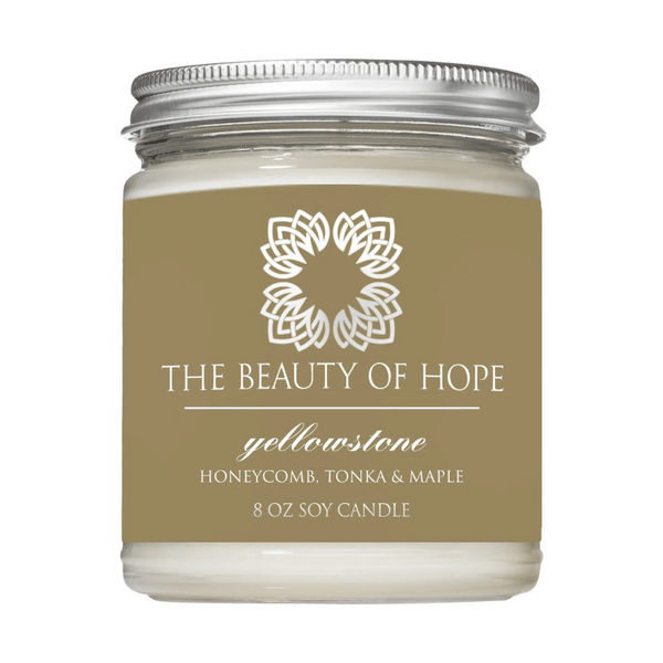 Yellowstone 8oz Candle | The Beauty of Hope in a glass jar with a silver lid, featuring honeycomb, tonka, and maple scent for a calming wellness experience.