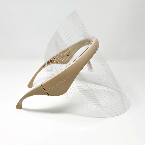 Beige LED Light Therapy Visor | Vie Healing with a clear, curved shield designed for skincare and wellness treatments, shown against a plain white background.