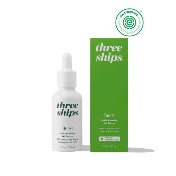 White dropper bottle next to green box packaging of Boost 49% Rosehip Oil Serum | Three Ships with EWG verified logo indicating clean skincare product.