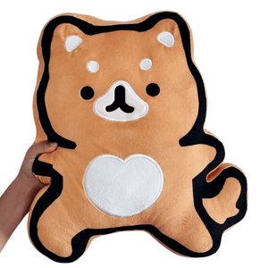 Hand holding a soft orange plush toy shaped like a fox with black and white accents, featuring a heart on its belly, called Warrior Fox Plushie | Lucky Owl.