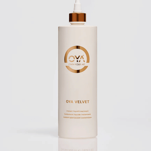 Tall white bottle with a gold cap labeled Velvet Instant Liquid Treatment | OYA, a skincare product for body care and wellness supplements.