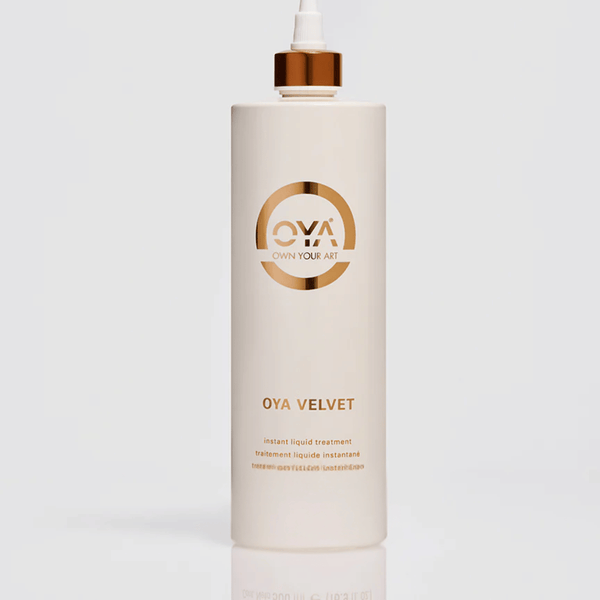 Tall white bottle with a gold cap labeled Velvet Instant Liquid Treatment | OYA, a skincare product for body care and wellness supplements.