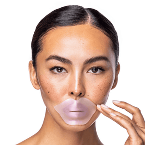 Close-up of a woman applying the Diamond Radiance Collagen Lip Mask | KNESKO, a translucent pink skincare lip treatment designed to hydrate and rejuvenate lips.