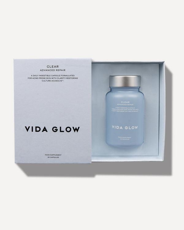 Clear Capsules | VIDA GLOW bottle with silver cap inside a light blue box, designed for skincare wellness supplements targeting acne-prone skin recovery and clarity.