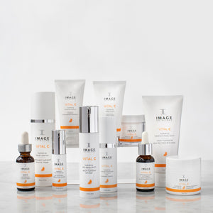 Collection of IMAGE Skincare VITAL C hydrating skincare products displayed on a reflective surface, featuring the VITAL C hydrating eye recovery gel | IMAGE Skincare in the foreground.