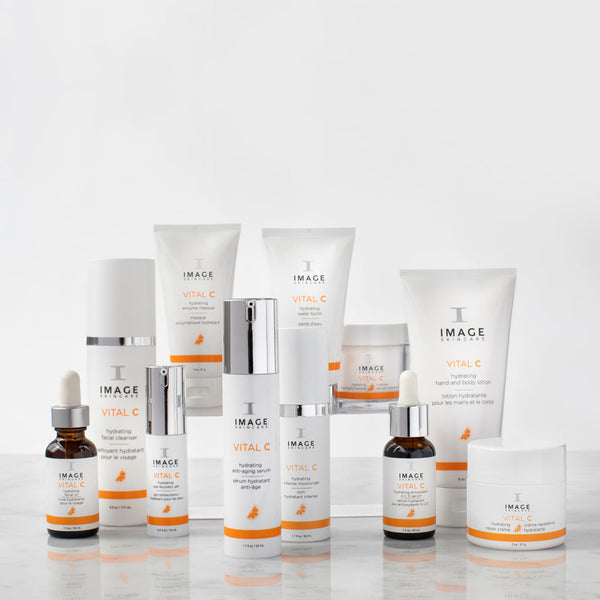Collection of IMAGE Skincare VITAL C hydrating skincare products displayed on a reflective surface, featuring the VITAL C hydrating eye recovery gel | IMAGE Skincare in the foreground.