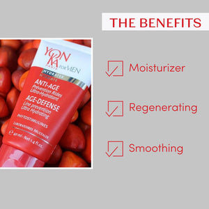 Red and white tube of Men’s Age Defense – Ultra-Hydrating, Line Prevention Cream I Yon-Ka Paris on a bed of red fruits alongside text highlighting its benefits as moisturizer, regenerating, and smoothing for skincare.