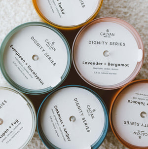 Top view of various scented candles arranged in a circle, featuring Aspen + Fog Dignity Series Glass Jar Soy Candle | Calyan Wax Co. - 5.3 oz with other fragrances visible.