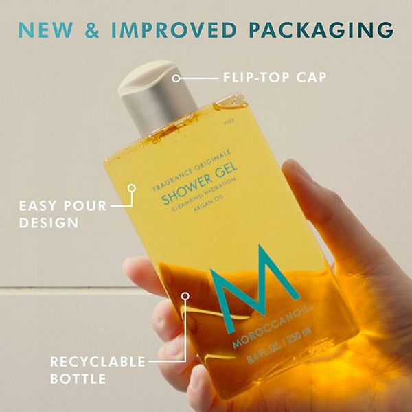 Hand holding a bottle of Shower Gel | Moroccanoil with new and improved packaging, featuring a flip-top cap, easy pour design, and recyclable bottle for skincare and body care.