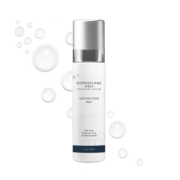 Bottle of Satisfaction Mist | DermaplanePro professional skincare spray with aloe, hyaluronic acid, and niacinamide, surrounded by water droplets on a white background.
