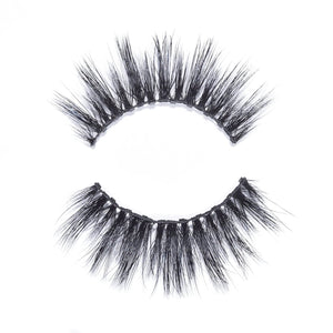 Close-up of a pair of dramatic, voluminous false eyelashes with a wispy design isolated on white background featuring Dolly Lash | Moxielash.