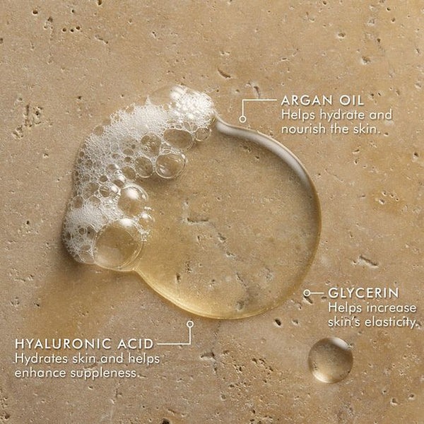 Close-up of clear and bubbly liquid droplets on a textured surface highlighting key skincare ingredients argan oil, glycerin, and hyaluronic acid promoting hydration, elasticity, and nourishment in Hand Wash | Moroccanoil.