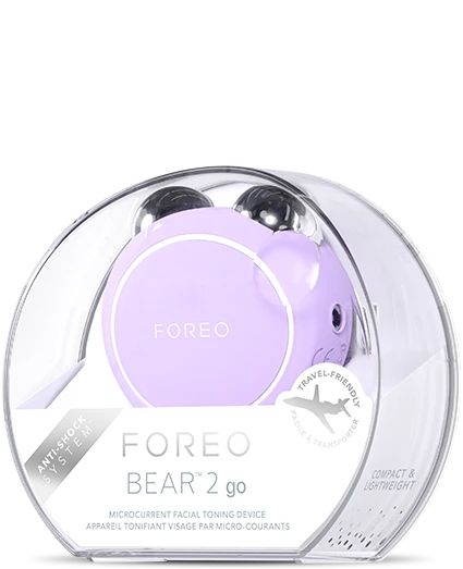 BEAR™ 2 Go | FOREO lavender microcurrent facial toning device in a transparent travel-friendly case, promoting skincare and wellness recovery.