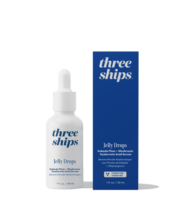 White dropper bottle and blue box packaging of Jelly Drops™ Kakadu Plum + Mushroom Hyaluronic Acid Serum | Three Ships displayed on a white background with branding and product details.
