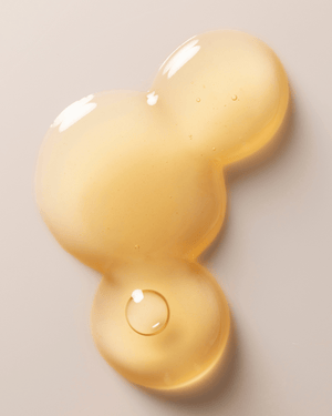 Close-up of a light golden serum drop with smooth texture and small air bubbles, representing Jelly Drops™ Kakadu Plum + Mushroom Hyaluronic Acid Serum | Three Ships skincare product.