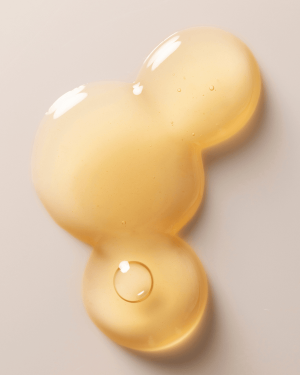 Close-up of a light golden serum drop with smooth texture and small air bubbles, representing Jelly Drops™ Kakadu Plum + Mushroom Hyaluronic Acid Serum | Three Ships skincare product.