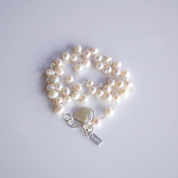 It's A Wrap Triple Pearl Bracelet | Liv & B featuring multiple strands of white freshwater pearls linked with silver chain and a decorative silver toggle clasp.