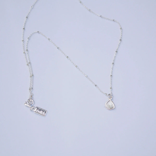 Diamond Slice Sterling Silver Necklace | Liv & B featuring a delicate sterling silver chain with a small diamond slice pendant and adjustable clasp.