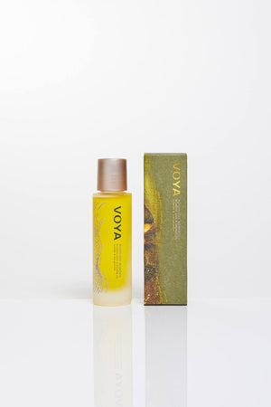 Bottle of Moonlight Moments Bath & Shower Oil | VOYA with golden liquid inside, next to its green and gold packaging, designed for skincare and body care wellness.