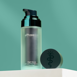 Night Serum | Althaea Skin in a frosted glass bottle with a black pump and matching black cap, displayed against a green background for skincare and wellness.
