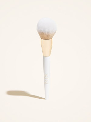 Bronzing Powder Brush | NUDA with soft, dense bristles and a sleek white handle accented by a gold ferrule, designed for flawless application of bronzing powder.