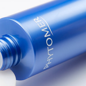 Close-up of a blue bottle labeled Phytomer, showcasing the packaging of Oléocrème Ultra-Moisturizing Body Milk | Phytomer for skincare and body care routines.