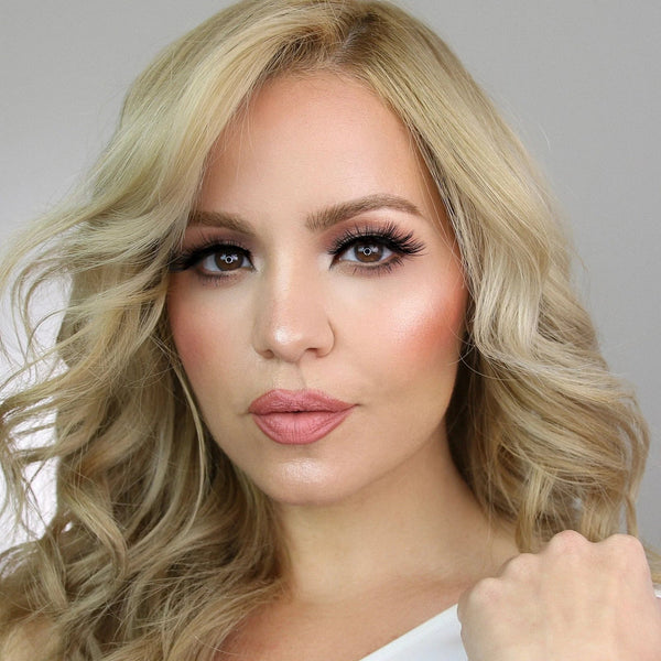 Close-up of a blonde woman with curled hair wearing dramatic lashes and natural makeup, showcasing Sexy Lash | Moxielash for a glamorous look.