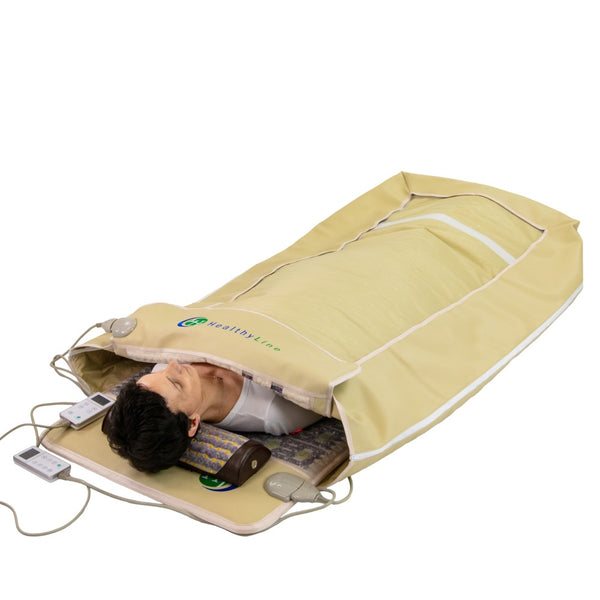 Man lying inside a TAJ-Mat™ Full 7224 Firm - Photon PEMF InfraMat Pro® | HealthyLine, a wellness device designed for body care and recovery with integrated control panels and heating elements.