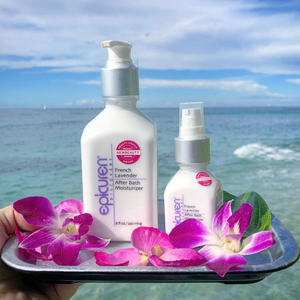 French Lavender After Bath Moisturizer | Epicuren Discovery bottles displayed on a tray with purple orchids by the ocean, highlighting skincare and body care relaxation.