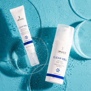 CLEAR CELL clarifying acne spot treatment | IMAGE Skincare displayed on a blue wet surface with two skincare product containers, highlighting refreshing and effective skincare solutions.