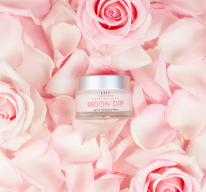 Jar of Evening Rose Moon Dip® Ageless Facial Sleep Mousse with Peptides + Retinol | Farmhouse Fresh surrounded by pink rose petals and fresh pink roses for a skincare and wellness theme.