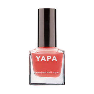 A bottle of Freya Nail Lacquer | YAPA in a coral shade with a sleek black cap, designed for professional nail application and beauty care.